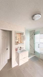 Hermoso apartaestudio en Orlando في أورلاندو: حمام أبيض مع حوض ومرآة +8 صور