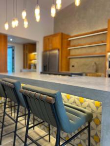 Villa 10 at Chial Reserve Exclusive Jungle Retreat في Big Eddy: مطبخ مع بار طويل وكراسي زرقاء