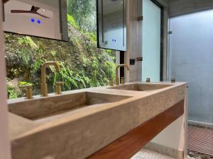 Villa 10 at Chial Reserve Exclusive Jungle Retreat في Big Eddy: حمام مع حوض كبير ونافذة +13 صورة