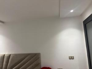 una camera da letto con un letto e una parete bianca di Choix a Kenitra