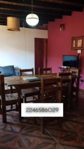 a dining room with a wooden table and chairs at Costero in Santa Teresita