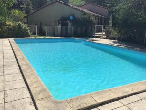 una piscina con agua azul frente a una casa en Gîte rural à Saint-Cybranet avec piscine privée, animaux admis - FR-1-616-502, en Saint-Cybranet