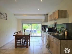 Una cocina con una mesa de madera y un comedor. en Gîte rural à Saint-Cybranet avec piscine privée, animaux admis - FR-1-616-502, en Saint-Cybranet