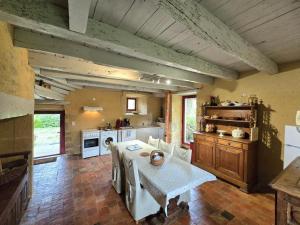Una cocina con una mesa y sillas en una habitación. en Charmante maison Périgord avec piscine privée et WIFI - FR-1-616-511, en Fonvielle