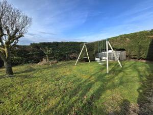 a swing set in a field with a tree at Maison de campagne confortable en Dordogne - FR-1-616-521 in Lala