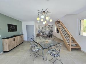 a dining room with a glass table and chairs at Charmante maison avec piscine chauffée privée au cœur du Périgord Noir - FR-1-616-530 in Prats-de-Carlux