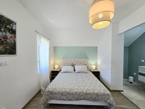 a bedroom with a bed and two tables and a lamp at Charmante maison avec piscine chauffée privée au cœur du Périgord Noir - FR-1-616-530 in Prats-de-Carlux