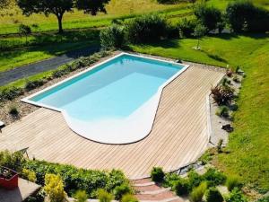 Una vista aérea de una gran piscina en una terraza de madera. en Charmante maison à Hautefort avec piscine privée, animaux admis - FR-1-616-514, en Boisseuilh
