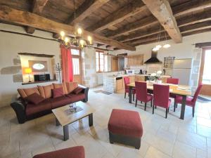 una sala de estar con un sofá y una mesa en Charmante maison à Hautefort avec piscine privée, animaux admis - FR-1-616-514, en Boisseuilh