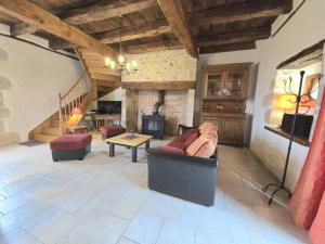 una sala de estar con un sofá y una mesa en Charmante maison à Hautefort avec piscine privée, animaux admis - FR-1-616-514, en Boisseuilh