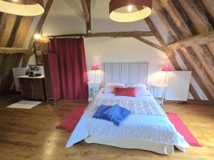 Un dormitorio con una gran cama blanca con almohadas rojas. en Charmante maison à Hautefort avec piscine privée, animaux admis - FR-1-616-514, en Boisseuilh