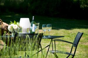 einen Tisch mit zwei Weingläsern und Blumen darauf in der Unterkunft Charming Mas With Medieval Church Views in Sainte-Croix-de-Beaumont