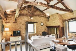 ein Wohnzimmer mit einer weißen Couch und einem Tisch in der Unterkunft Charming Mas With Medieval Church Views in Sainte-Croix-de-Beaumont