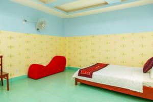 a bedroom with a bed and a red chair at Như Quỳnh Hotel HCM in Ho Chi Minh City +28 photos