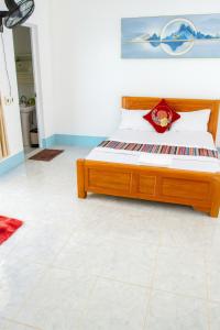 a bed with a wooden frame in a room at Như Quỳnh Hotel HCM in Ho Chi Minh City