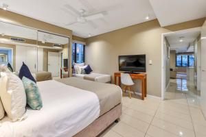 Darwin Waterfront Luxury Suites في داروين: غرفة نوم بها سرير كبير وتلفزيون