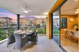 Darwin Waterfront Luxury Suites في داروين: غرفة طعام مع طاولة وكراسي على شرفة