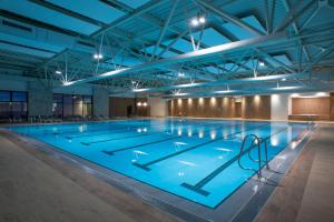 una grande piscina in un grande edificio con un grande soffitto di voco - Podgorica by IHG a Podgorica
