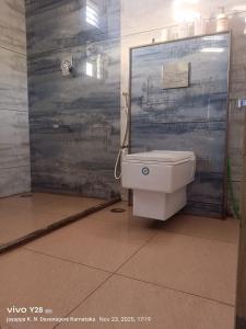 ein Bad mit einem WC vor einer Tür in der Unterkunft Aakruthi Homestay in Davanagere