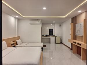 a hotel room with two beds and a kitchen at Lanta Mother House in Ko Lanta