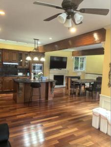 a living room with a ceiling fan and a kitchen at Kerrisdale cozy house in Vancouver
