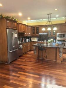 a kitchen with wooden floors and a stainless steel refrigerator at Kerrisdale cozy house in Vancouver