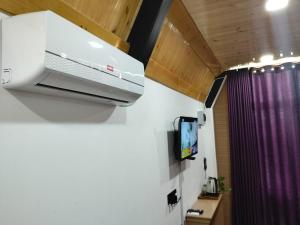 een tv aan de muur van een kamer bij Bliss den in Bandarawela +6 foto's
