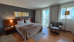 a hotel room with a bed and a chair at Barra First Class in Rio de Janeiro +142 photos