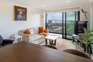 una sala de estar con una mesa y un sofá en Manchester Square Urban Stay - Easy To Everything, en Christchurch
