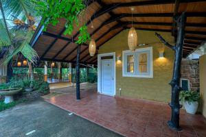 Un porche de una casa con una puerta blanca. en Spirit of Life Ayurveda and Yoga Resort, en Induruwa