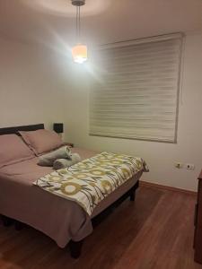 a bedroom with a bed and a window with a blind at Sector Norte 1 Dormitorio in Antofagasta