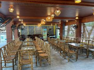 ein großes Esszimmer mit Holztischen und Stühlen in der Unterkunft Trang An River Sunshine Bungalow in Xuân Sơn