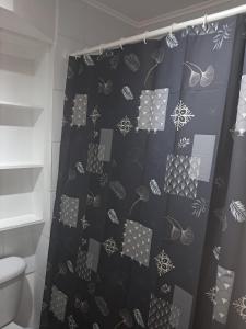 Sector Norte 1 Dormitorio في أنتوفاغاستا: حمام مزود بستارة دش سوداء ورمادية
