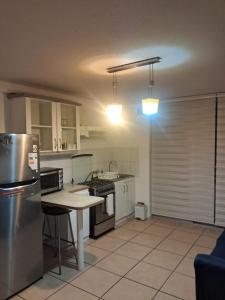 a kitchen with a refrigerator and a table in it at Sector Norte 1 Dormitorio in Antofagasta +10 photos