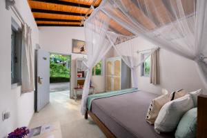un dormitorio con una cama con dosel en Spirit of Life Ayurveda and Yoga Resort, en Induruwa
