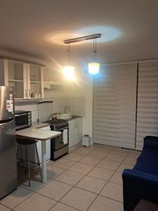 a kitchen with a stove and a table in it at Sector Norte 1 Dormitorio in Antofagasta