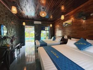 zwei Betten in einem Zimmer mit Holzwänden in der Unterkunft Trang An River Sunshine Bungalow in Xuân Sơn + 91 Fotos
