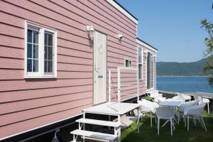 a pink building with chairs and tables on the side at 宮島リゾート Hauol'i in Hatsukaichi