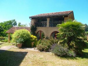 una casa con un jardín con una palmera en Gîte Confortable à Saint-Sulpice-d'Excideuil avec Internet - FR-1-616-533, en Fonvielle