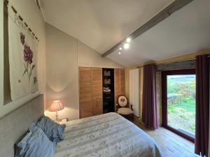 Un dormitorio con una cama grande y una ventana. en Gîte Confortable à Saint-Sulpice-d'Excideuil avec Internet - FR-1-616-533, en Fonvielle