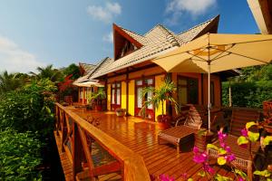 Casa con terraza de madera con sombrilla en Pousada Pedras Secas, en Fernando de Noronha