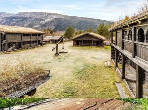 an old farm with buildings and mountains in the background at Jørundgard Vikingcamp in Sel