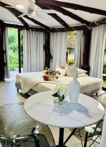 a room with two beds and a table with flowers on it at Hotel Villa La Fortuna in Filipina