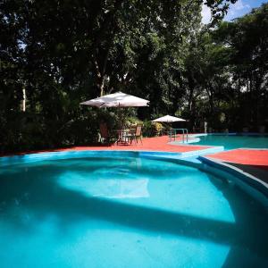 a large blue swimming pool with chairs and umbrellas at Hotel Boutique Canto Del Agua in Chiconcuac