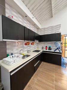 Finca Fusagasugá Villa Luisa في فوساغاسوغا: مطبخ مع دواليب سوداء ومغسلة