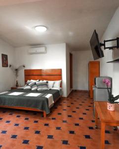 a bedroom with a bed and a television and a table at Hotel Boutique Canto Del Agua in Chiconcuac +16 photos