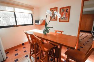 a dining room table with a vase of flowers on it at Hotel Boutique Canto Del Agua in Chiconcuac