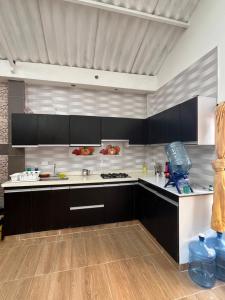 Finca Fusagasugá Villa Luisa في فوساغاسوغا: مطبخ مع خزائن سوداء وقمم منضدة بيضاء +8 صور