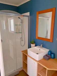 een badkamer met een witte wastafel en een douche bij Redshed Studio Mangawhai in Mangawhai +6 foto's