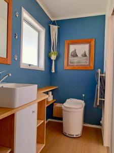 een badkamer met een wit toilet en een wastafel bij Redshed Studio Mangawhai in Mangawhai
